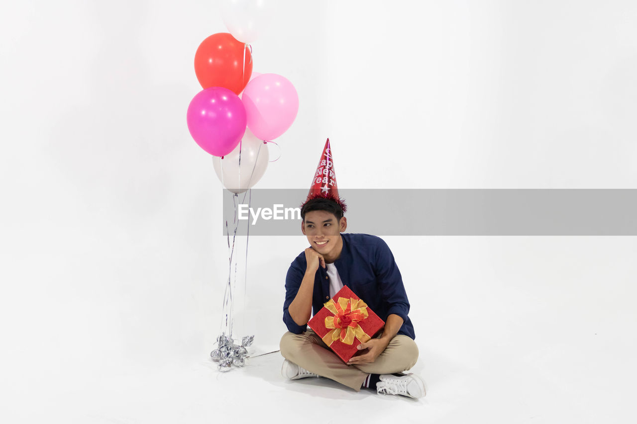 MAN HOLDING BALLOONS WITH BALLOON