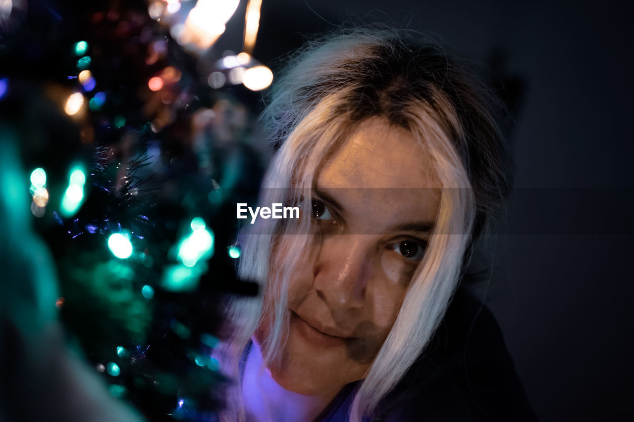 Portrait of woman by christmas tree