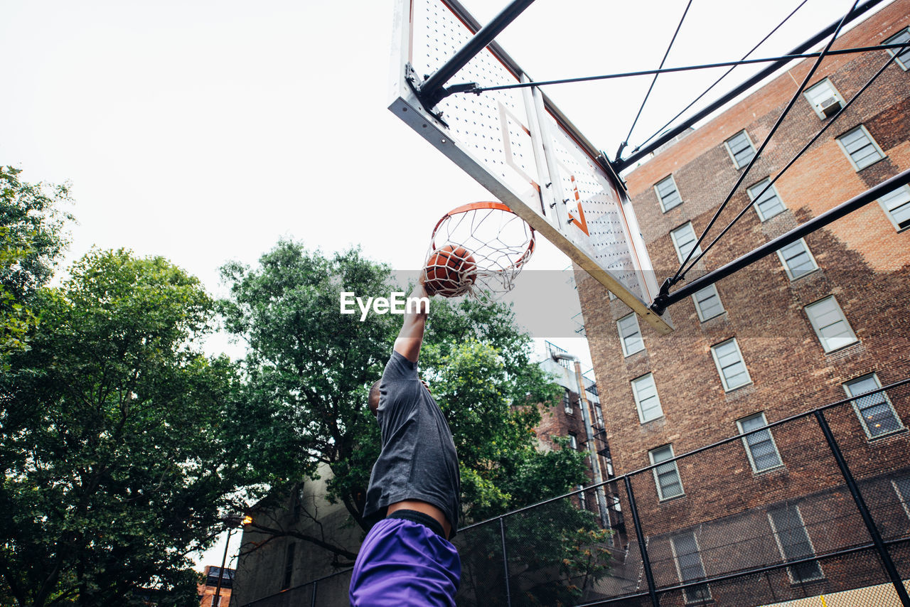 Low angle view of young man playing basketball