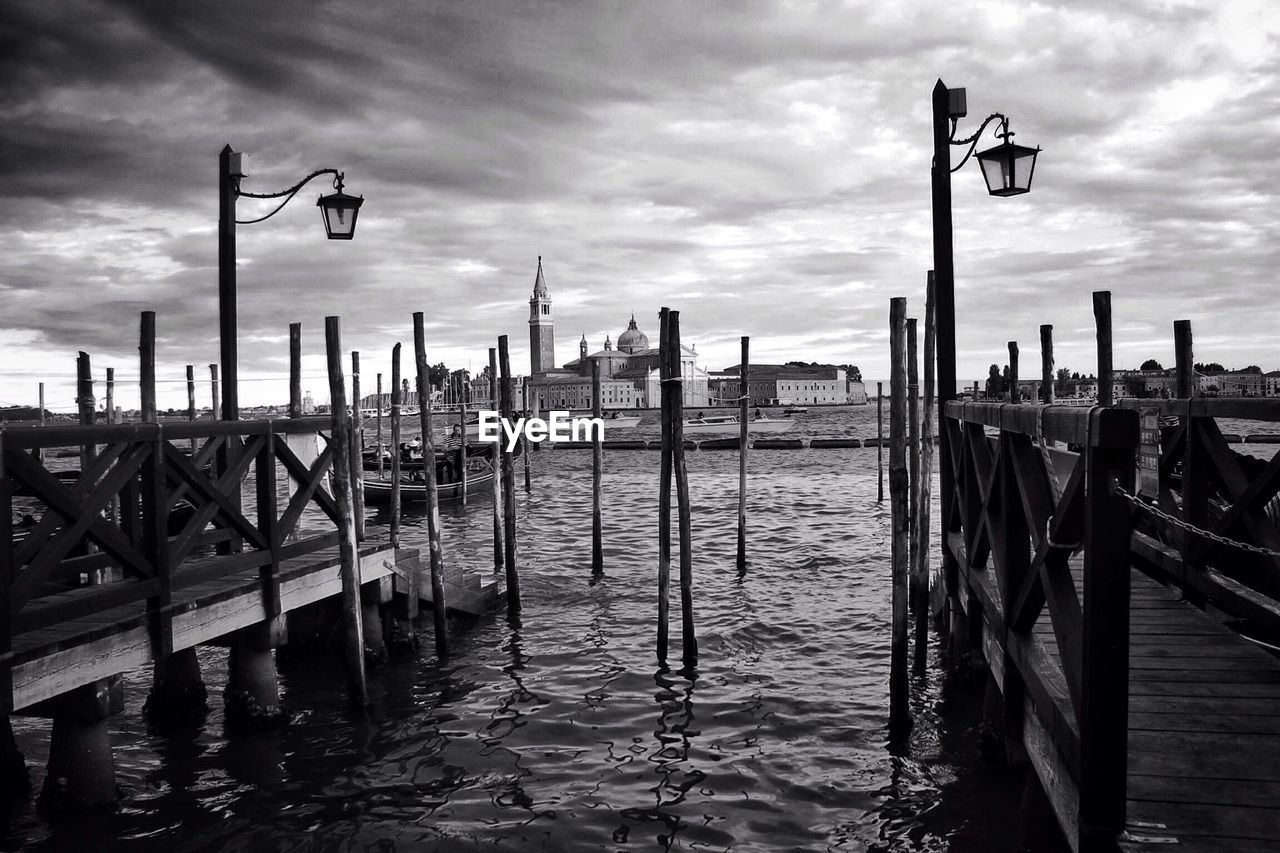 Pier on sea against cloudy sky