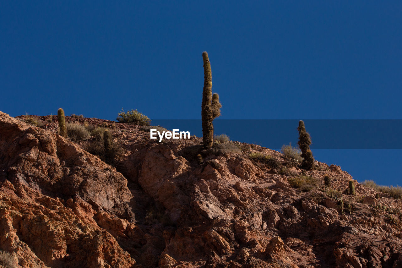 Low angle view of rock formation against clear blue sky
