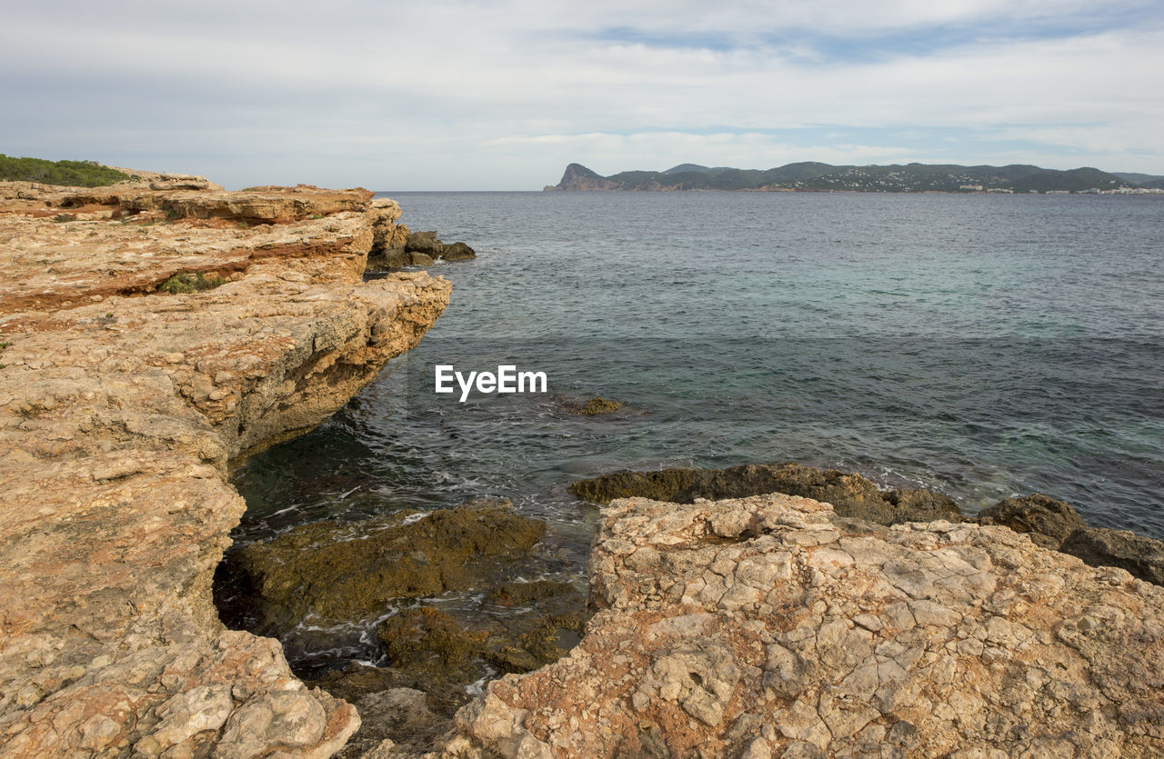 SCENIC VIEW OF ROCK FORMATION IN SEA AGAINST SKY