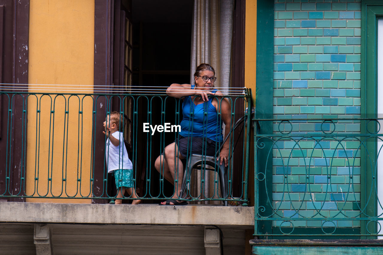 PEOPLE SITTING AT RAILING