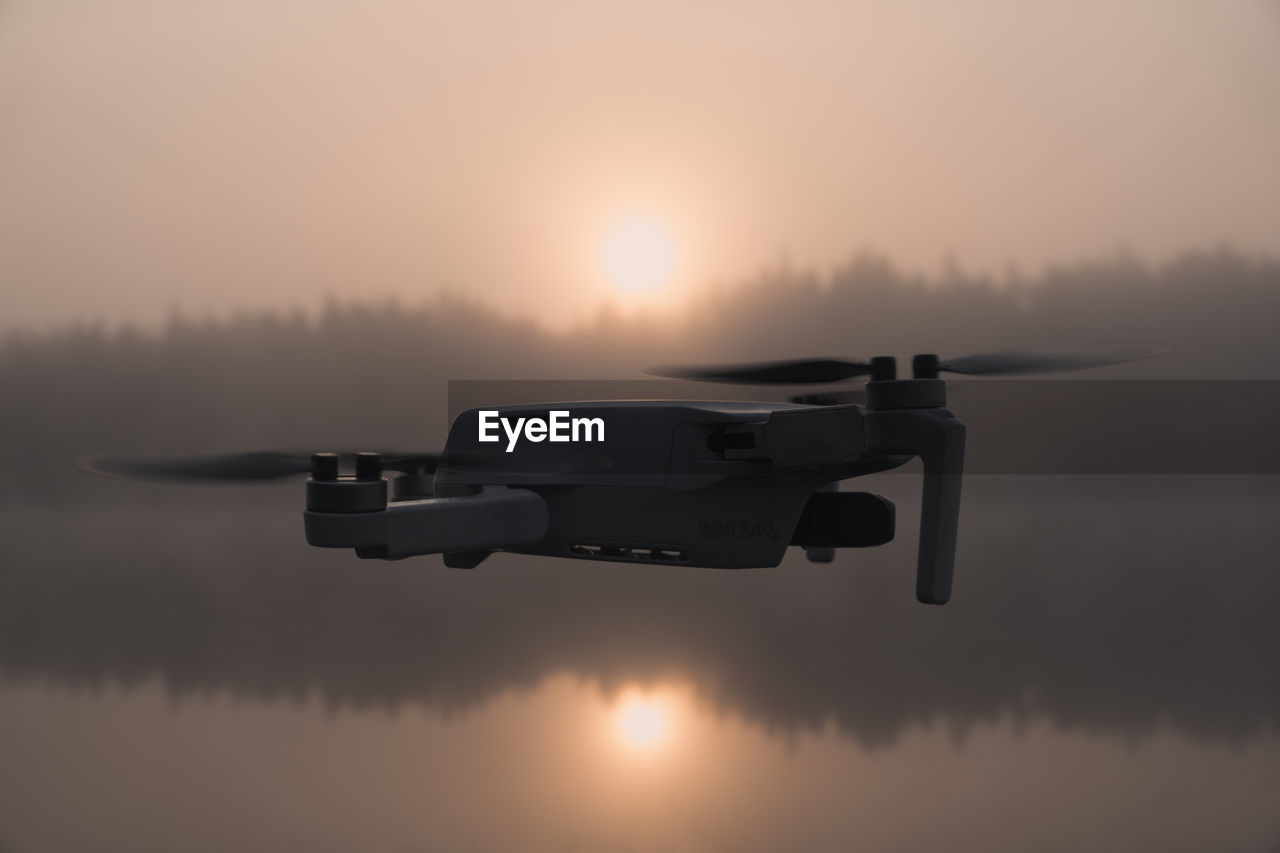 sky, vehicle, aircraft, airplane, sunset, nature, aviation, transportation, reflection, water, wing, no people, mode of transportation, flying, air vehicle, lake, military aircraft, sun, fog, outdoors, cloud, single object