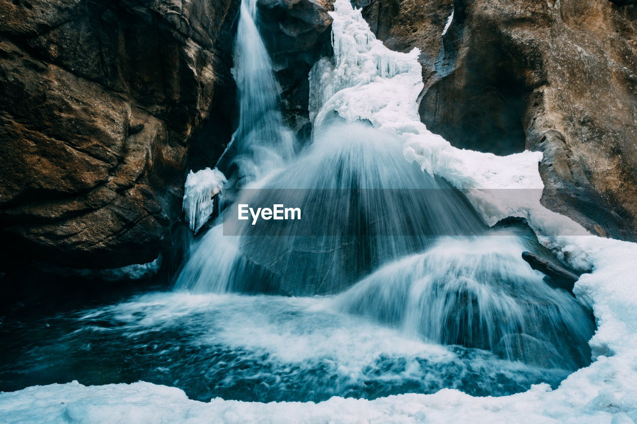 Scenic view of waterfall against rocks 