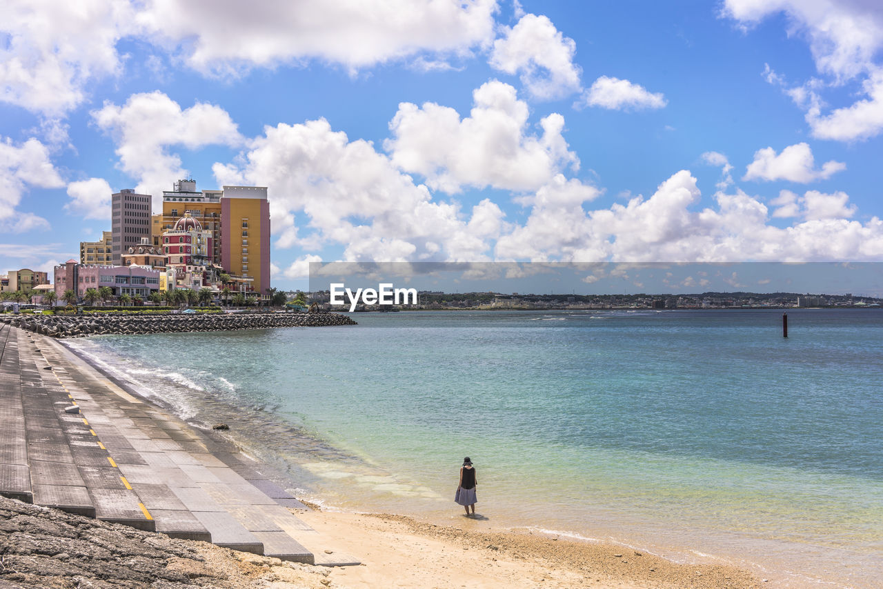 Woman from behind on the beach in the vicinity of the american village in chatan city of okinawa.