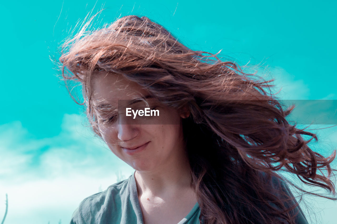 Low angle view of beautiful young woman against sky