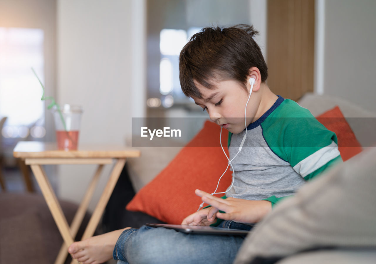 Boy using digital tablet at home