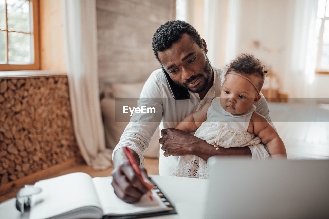 Father and son using smart phone at home