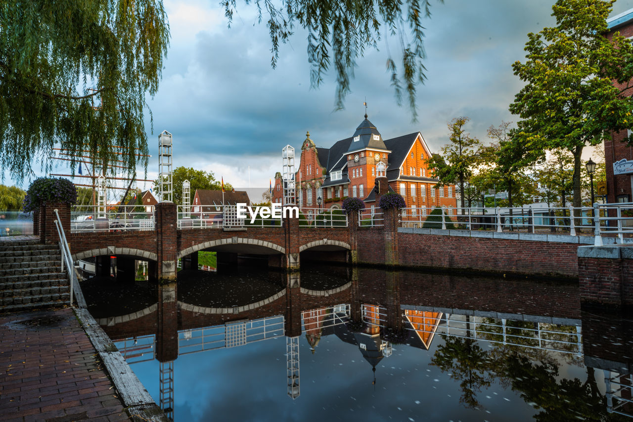 Arch bridge over river against buildings