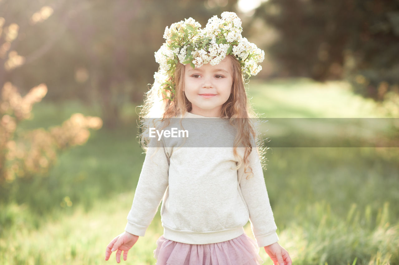 Portrait of girl wearing wreath at park