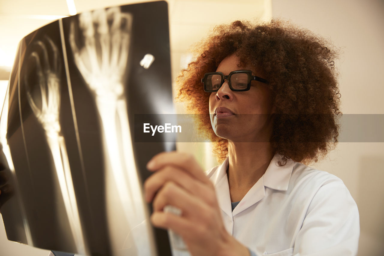 Doctor with eyeglasses examining x-ray in medical clinic at hospital