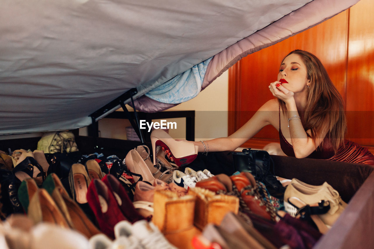 Teenager showing off her large collection of shoes, sneakers and heels.