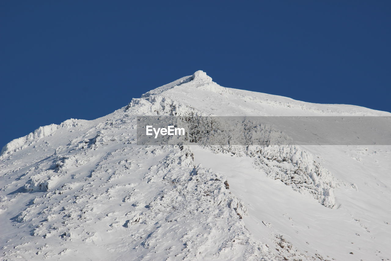 Scenic view of snowcapped mountains against clear blue sky