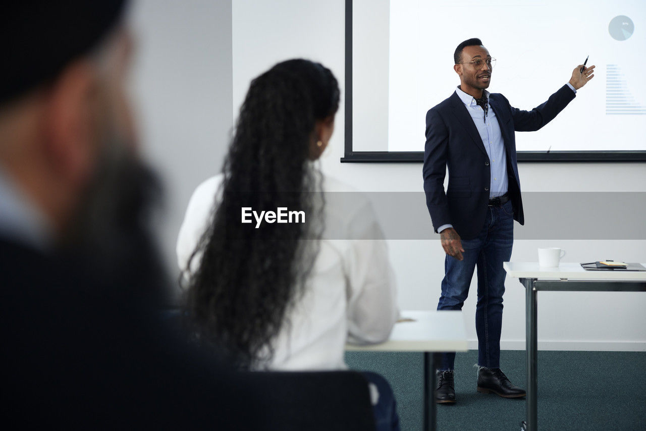 Businessman presenting before colleagues during meeting