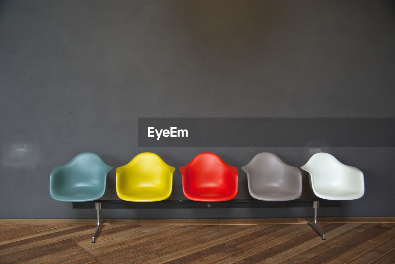 Colorful seats on hardwood floor against gray wall