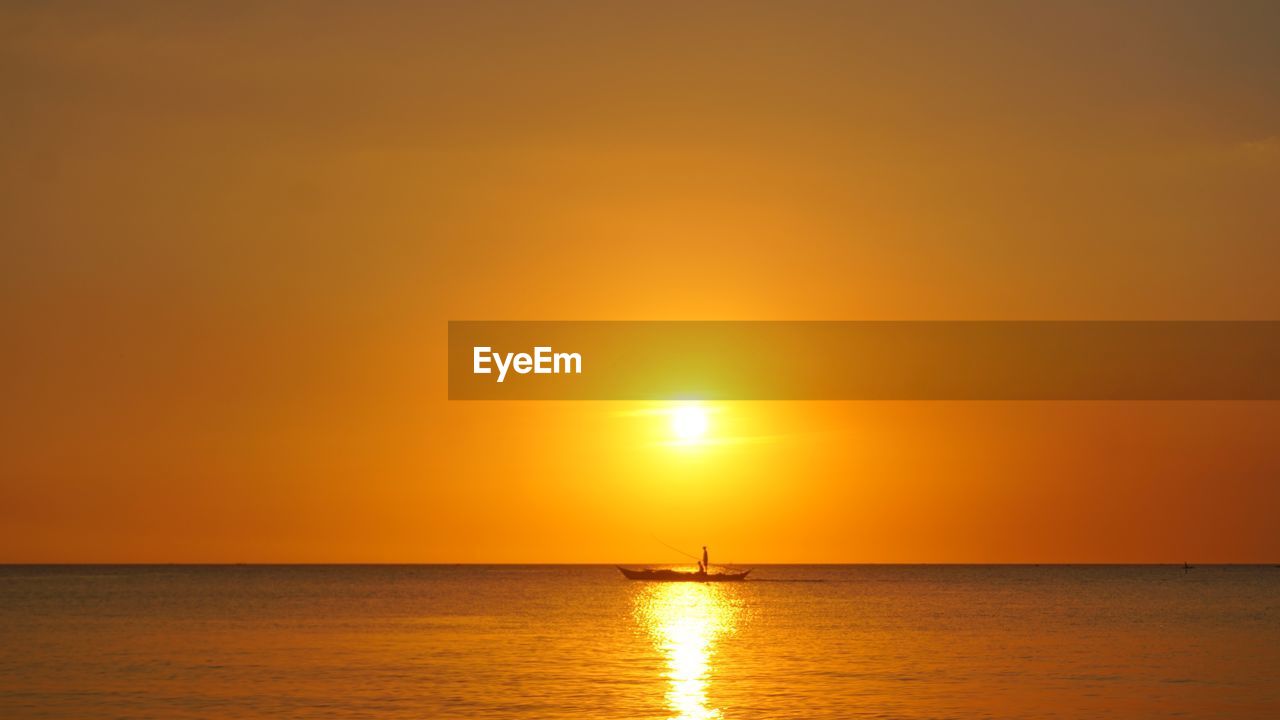 Scenic view of sea against orange sky