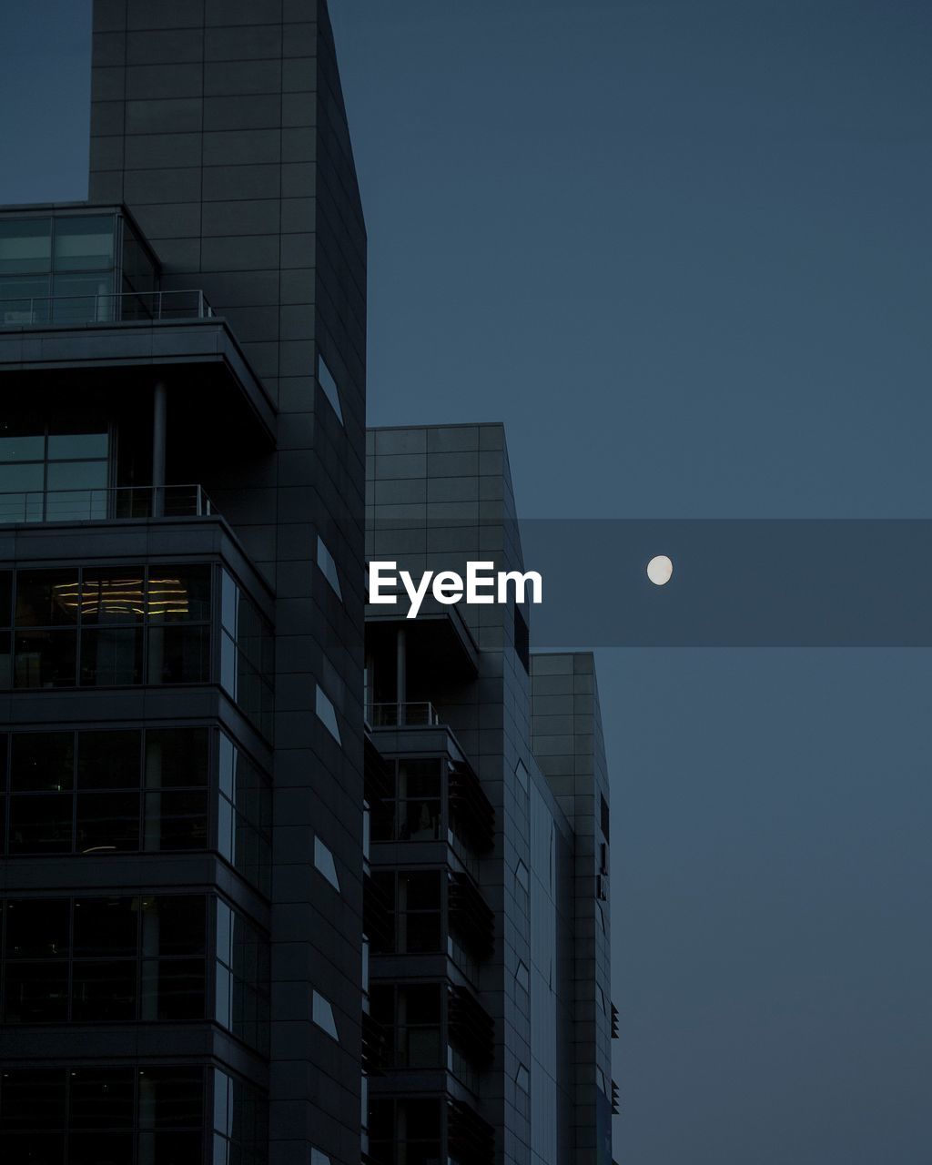 Low angle view of modern buildings against sky at dusk