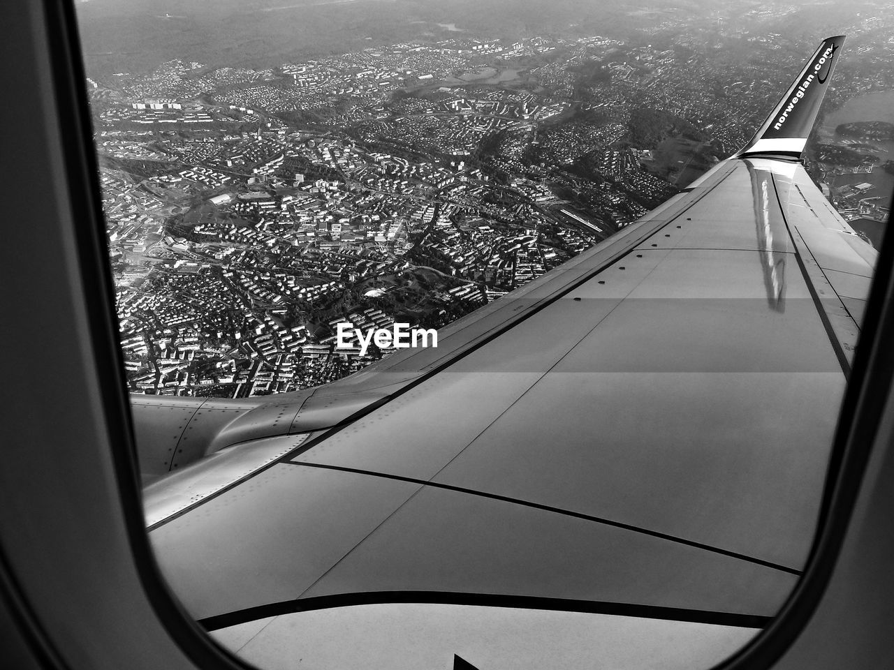 CROPPED IMAGE OF AIRPLANE WING OVER LANDSCAPE