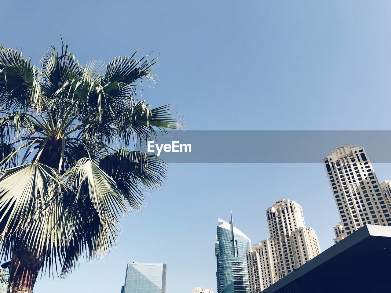 LOW ANGLE VIEW OF TALL BUILDINGS AGAINST CLEAR BLUE SKY