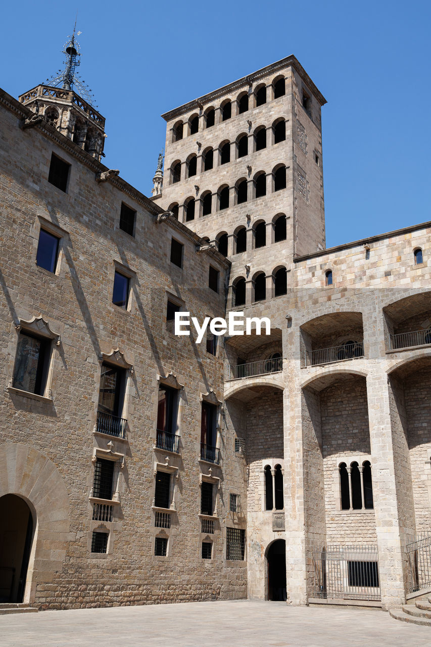 low angle view of old building against clear blue sky