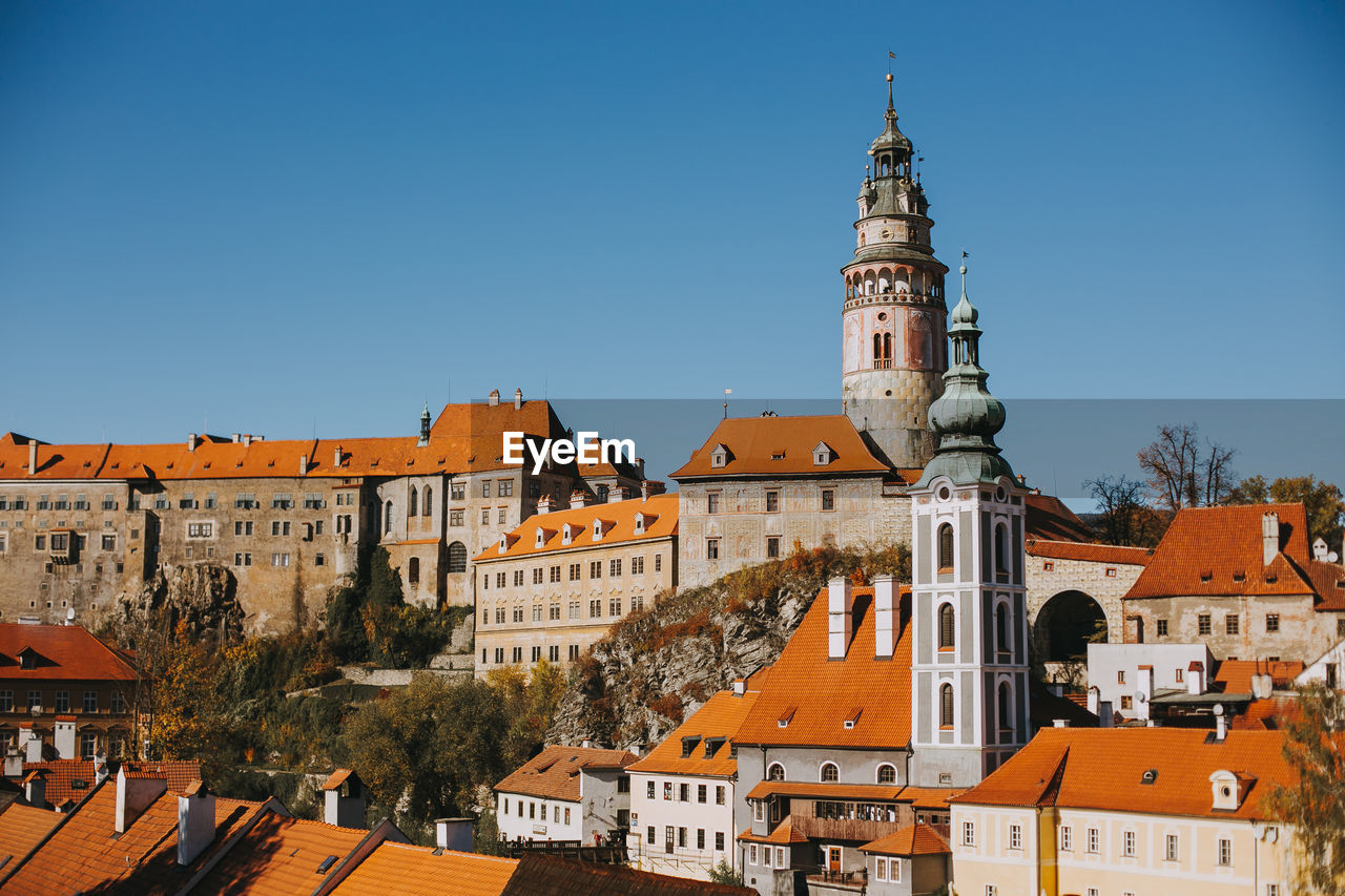 Buildings in city against clear blue sky