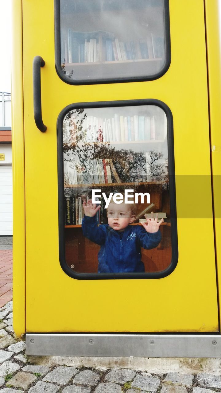 Boy looking through glass door