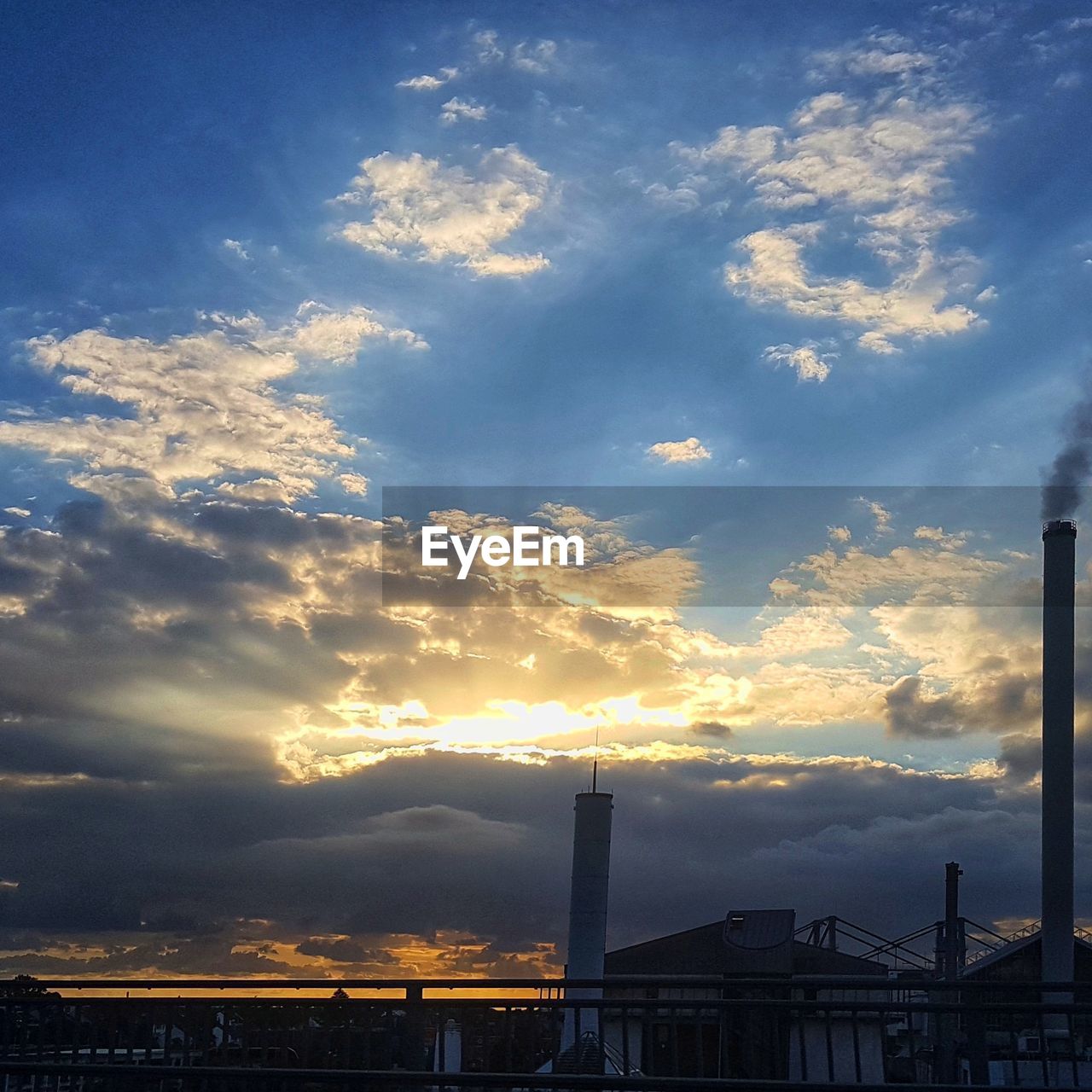 LOW ANGLE VIEW OF FACTORY AGAINST SKY DURING SUNSET