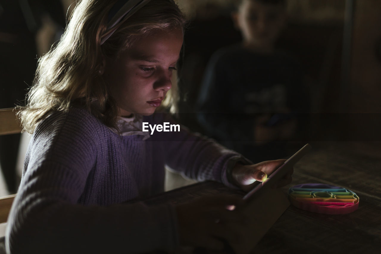 Girl using tablet pc at table in home