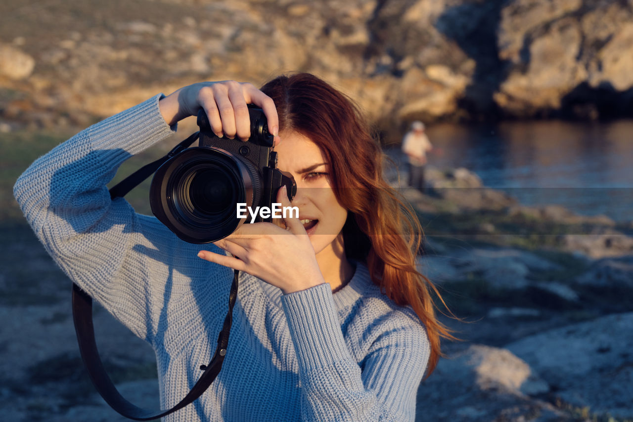 PORTRAIT OF WOMAN PHOTOGRAPHING OUTDOORS