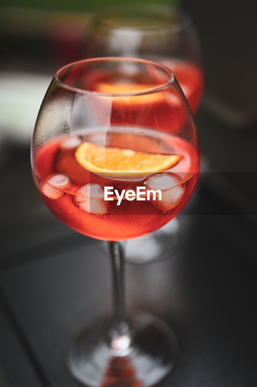 glass, refreshment, alcohol, drink, food and drink, alcoholic beverage, wine glass, drinking glass, wine, household equipment, cocktail, red, no people, close-up, distilled beverage, rose wine, focus on foreground, stemware, freshness, food, fruit, produce, indoors
