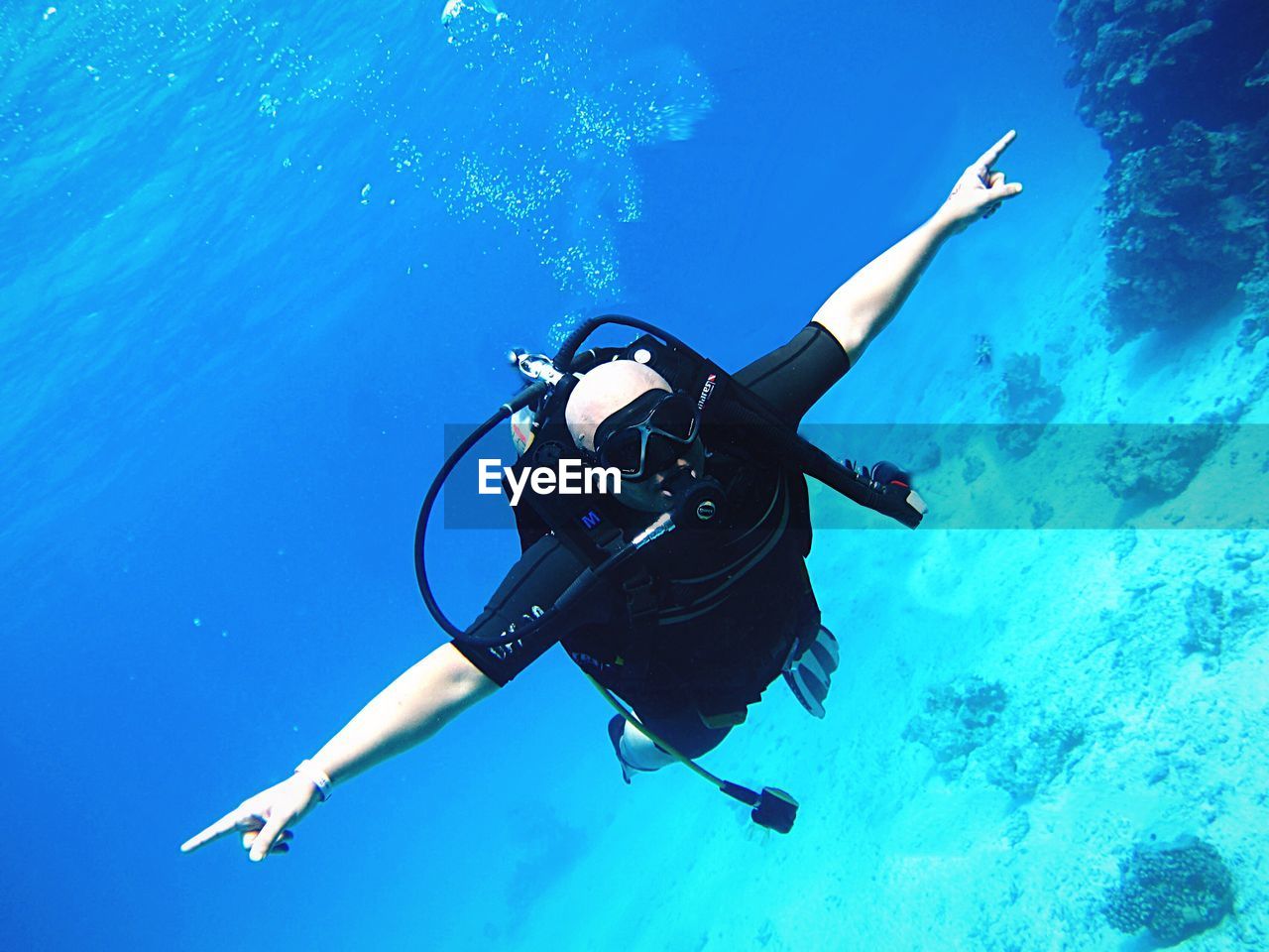 Man with arms outstretched scuba diving in sea