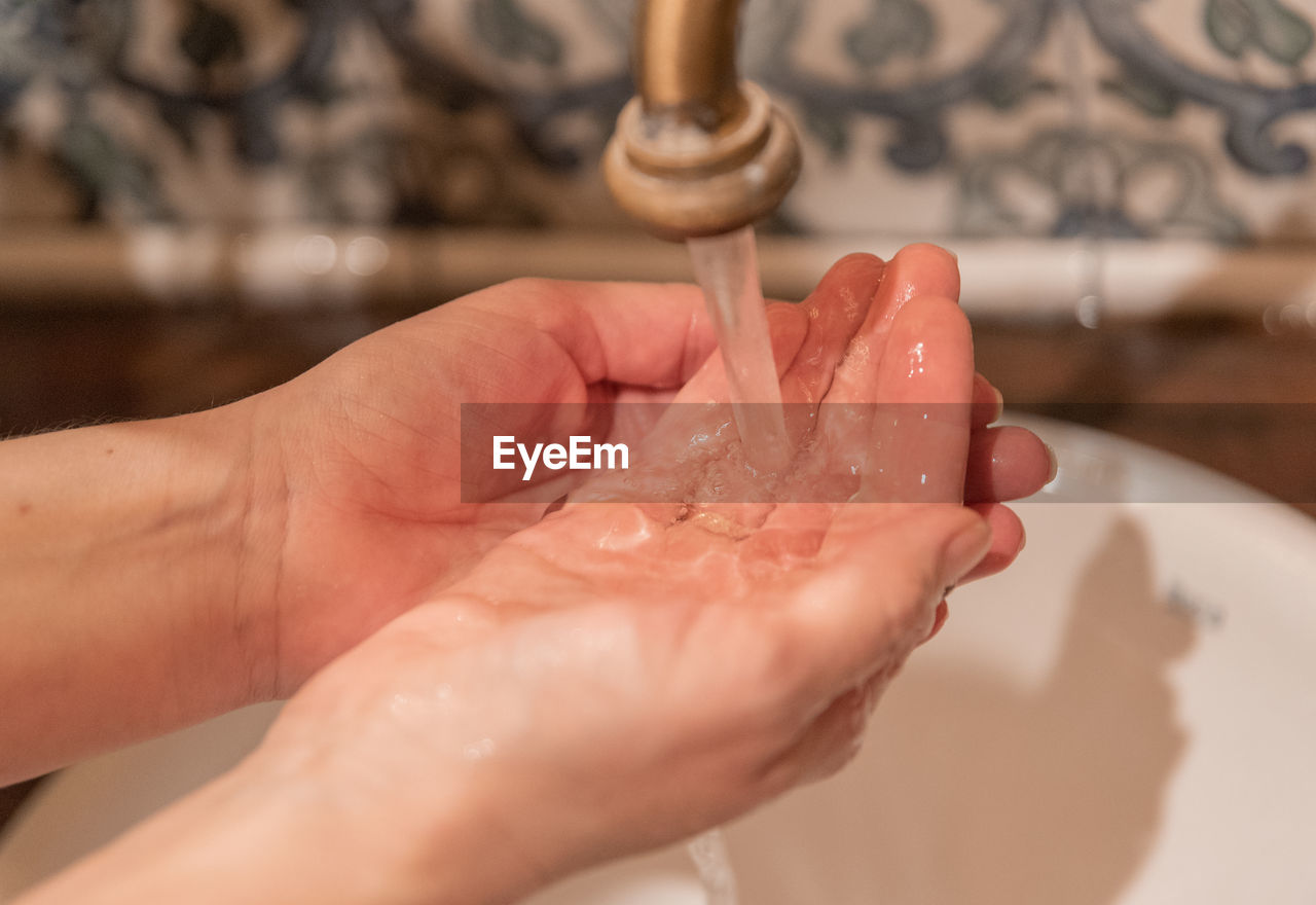 hand, limb, human leg, skin, cleaning, sink, indoors, nail, adult, finger, washing, water, domestic room, hygiene, close-up, home, women, holding, body care, one person, food, washing hands