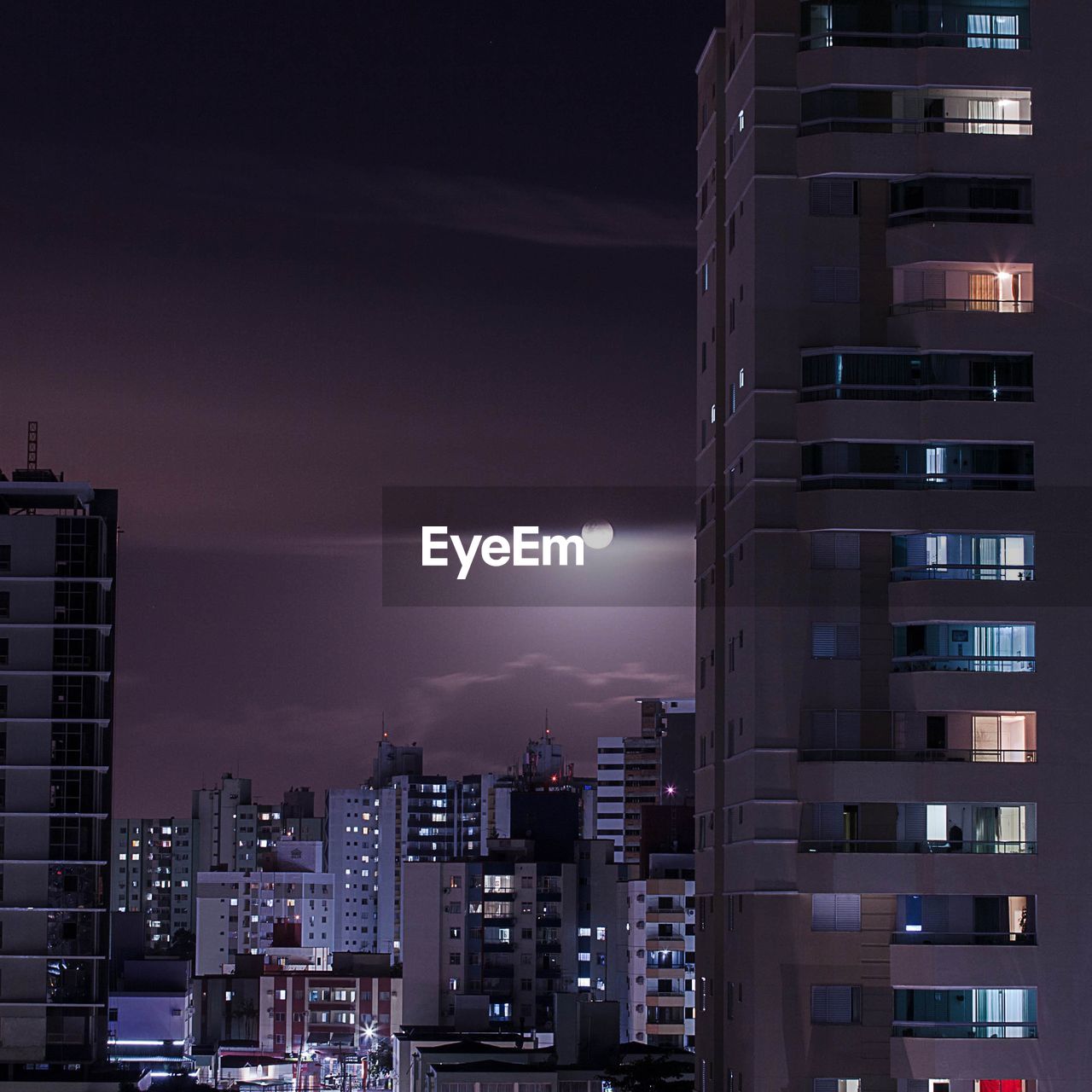 Illuminated buildings against sky at night