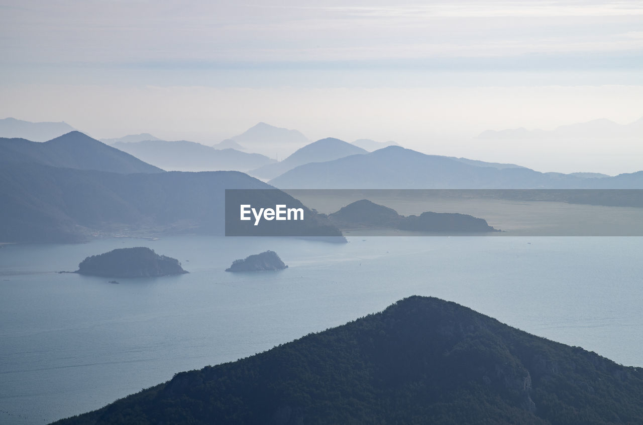 Scenic view of sea and mountains against sky