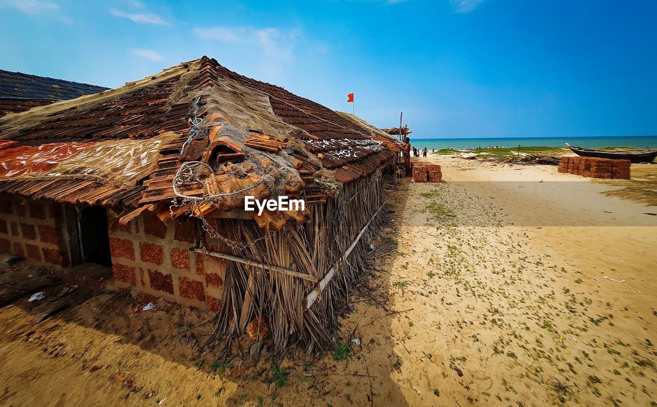 Abandoned building by sea against sky