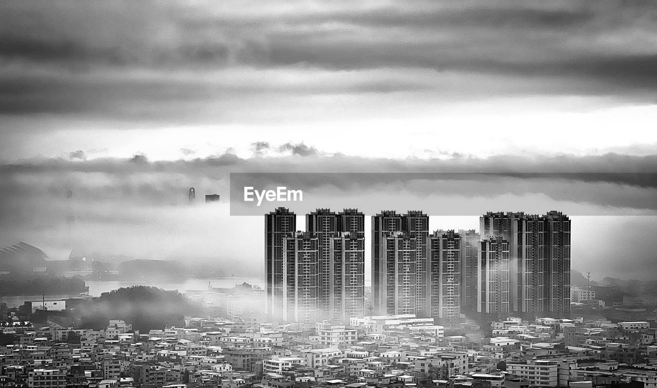 Cityscape against cloudy sky