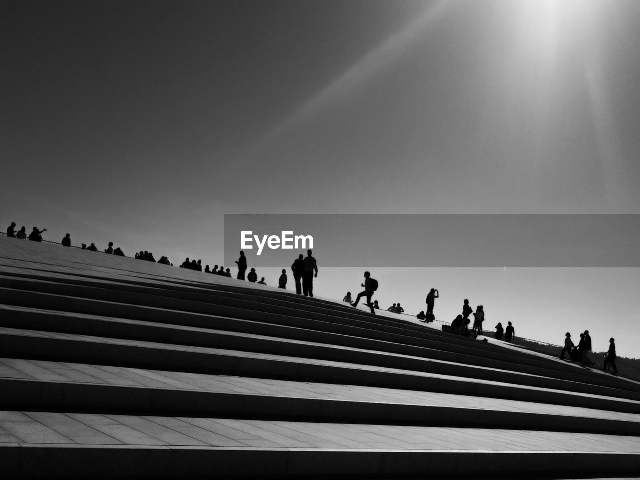 Low angle view of people on steps against sky