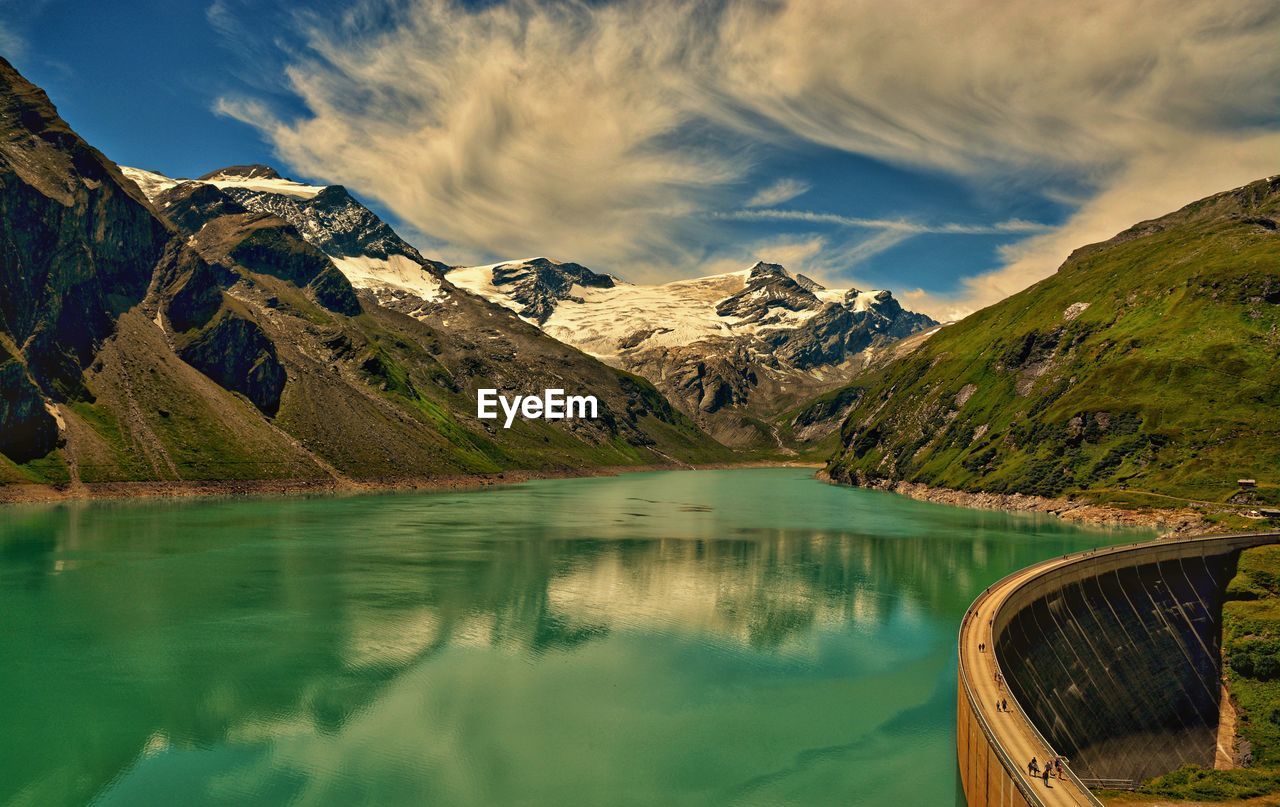 Scenic view of lake by mountains against sky