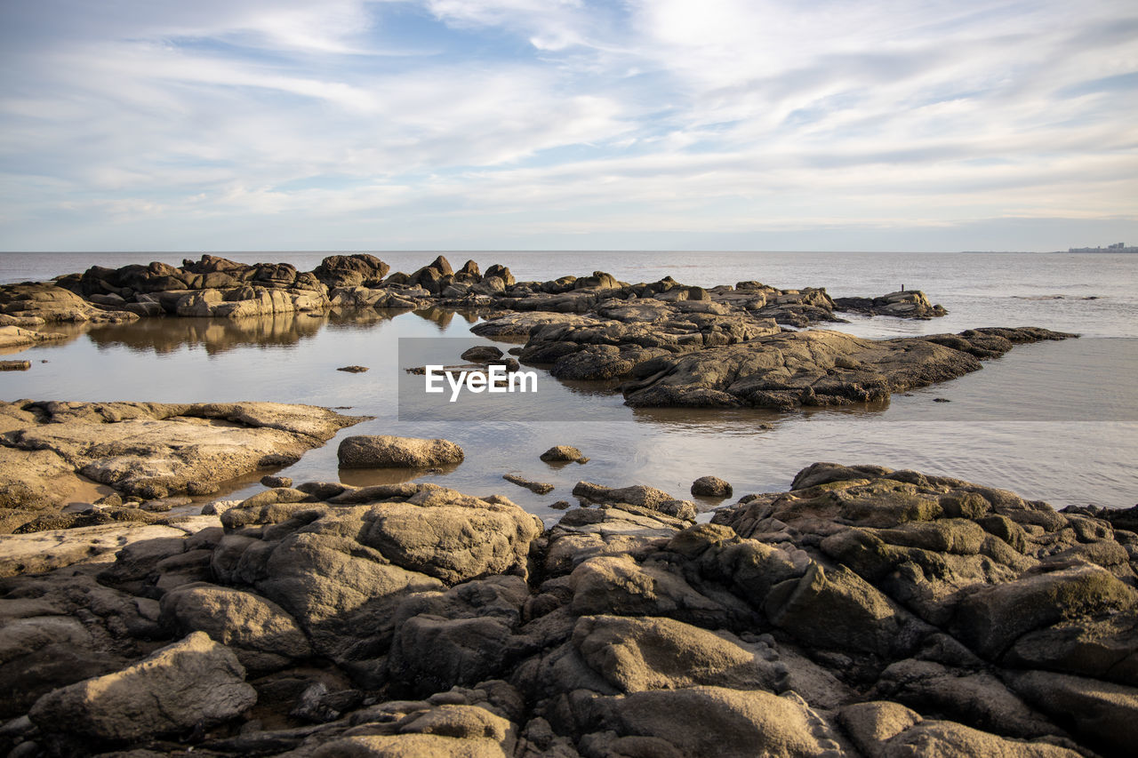 Rocks on beach against sky