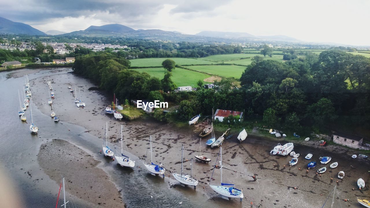 High angle view of boats moored at harbor by river against sky