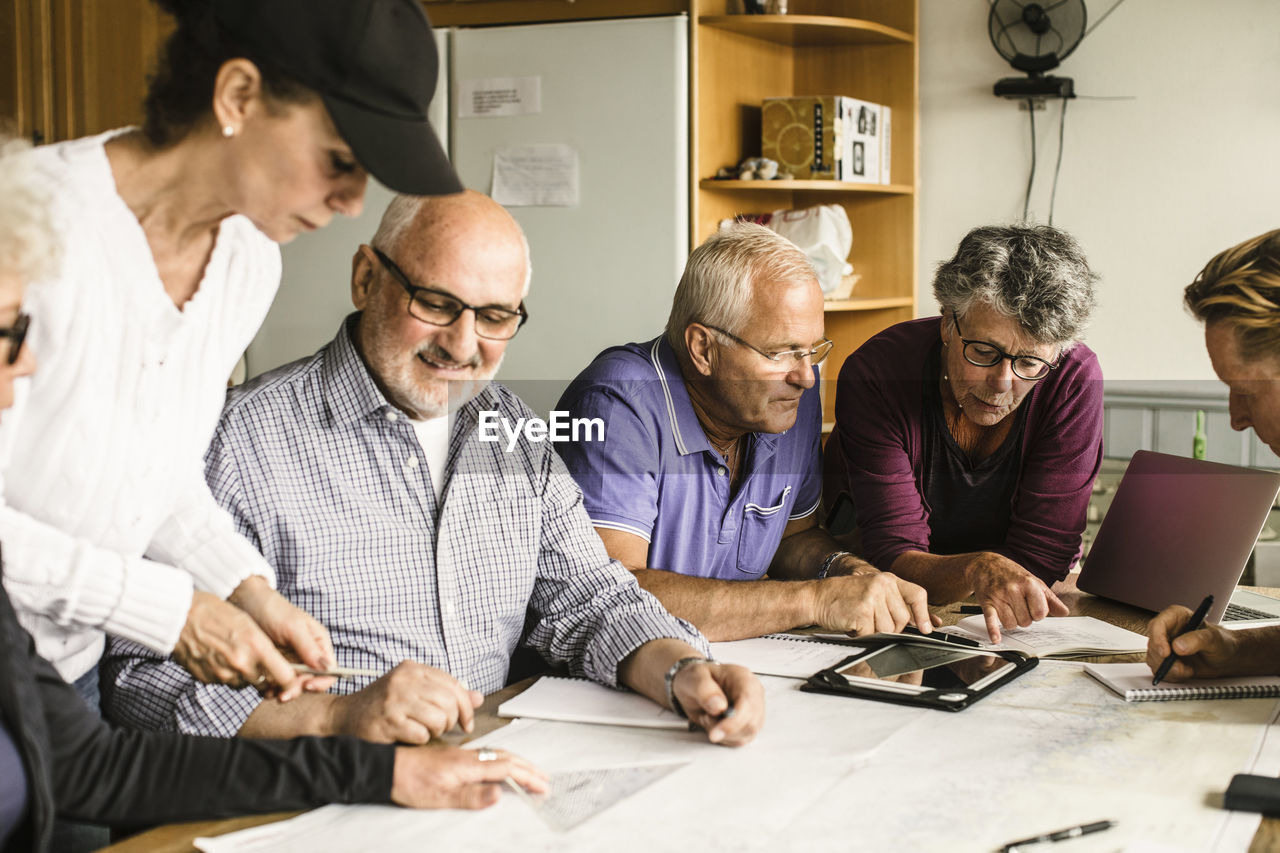 Senior men and women discussing at table during navigation course