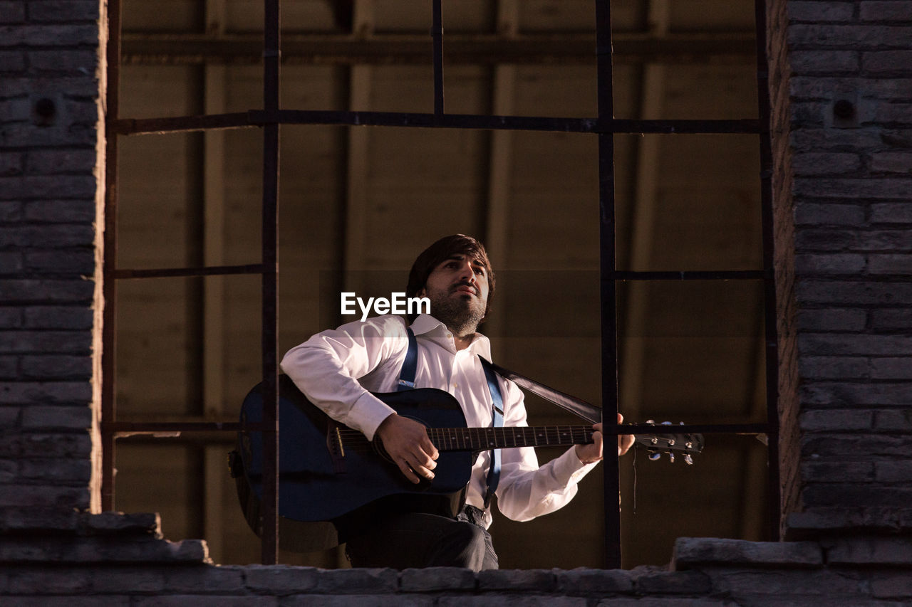 Man playing guitar at abandoned building