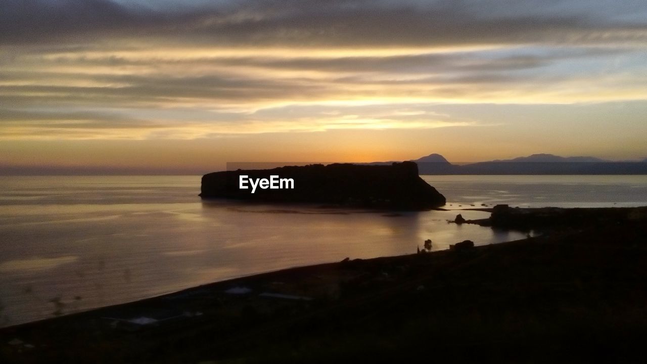 View of calm beach against scenic sky