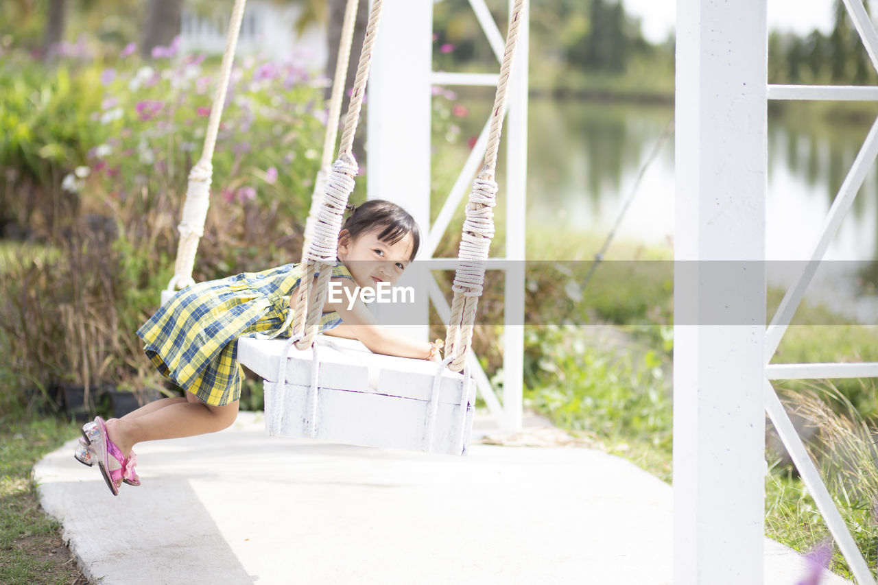 portrait of young woman sitting on swing