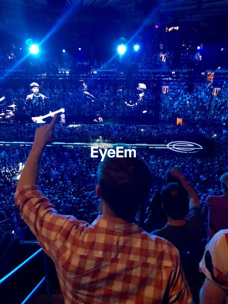 REAR VIEW OF PEOPLE ENJOYING AT MUSIC CONCERT AT NIGHT