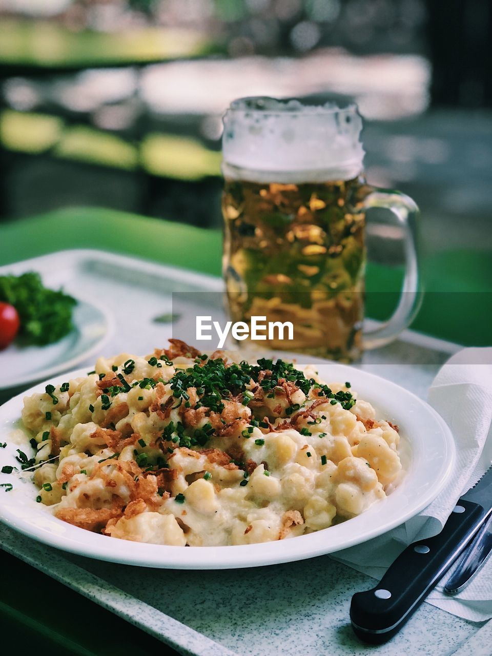 Close-up of pasta served with beer on table