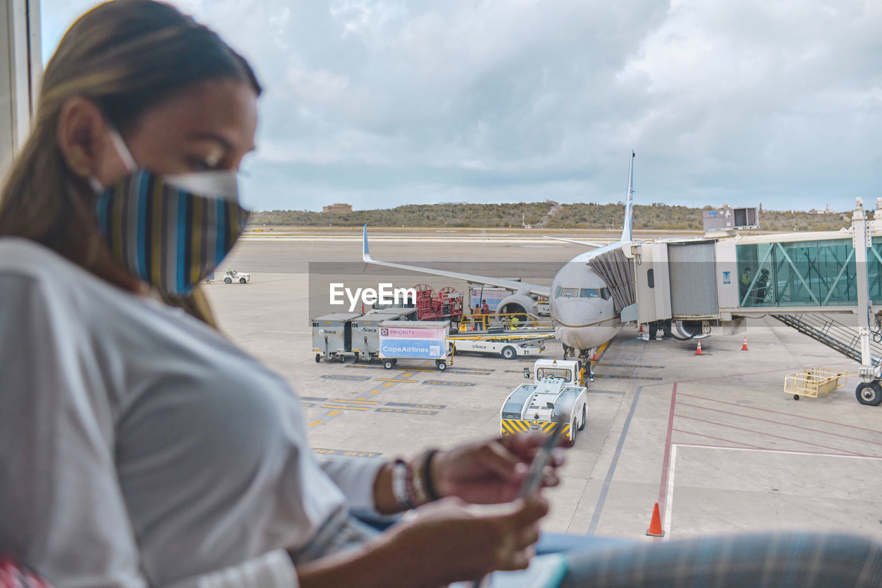 Young woman waiting to board the plane in the lounge the simon bolivar airport,  venezuela.