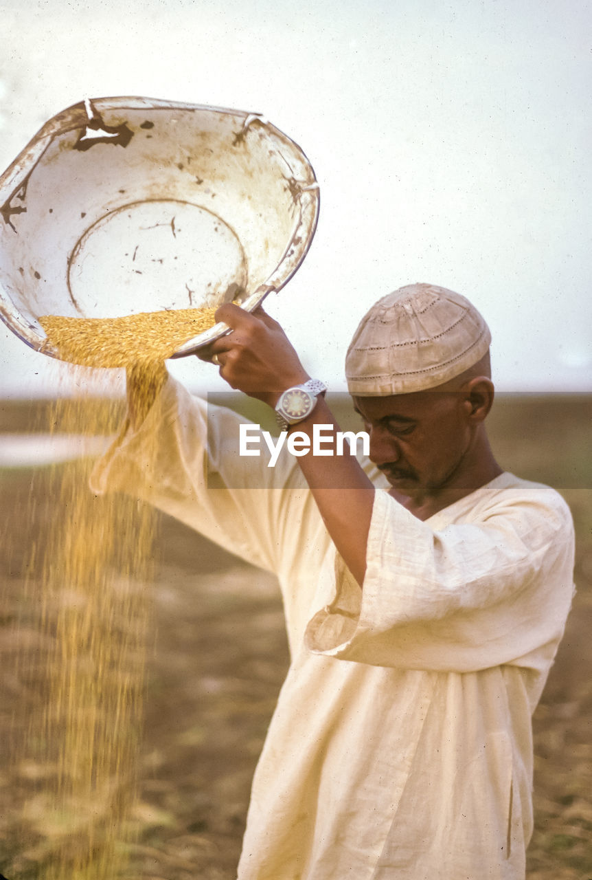 PORTRAIT OF MAN HOLDING WATER WITH REFLECTION