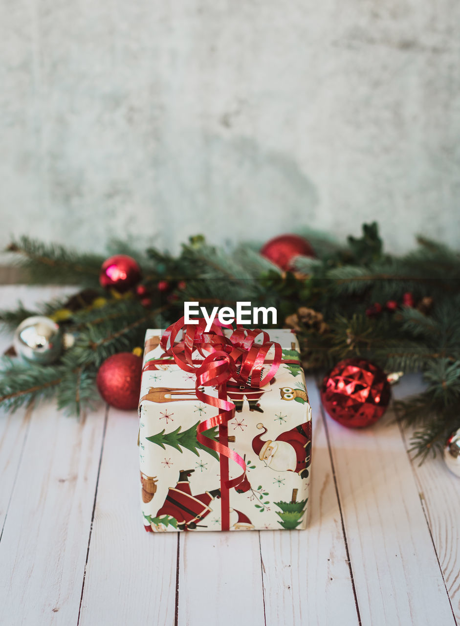 Christmas gift on white wood table top with christmas decor.